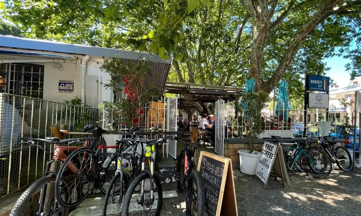 Dario's Café from Main Road, under the trees, with bicycles parked outside