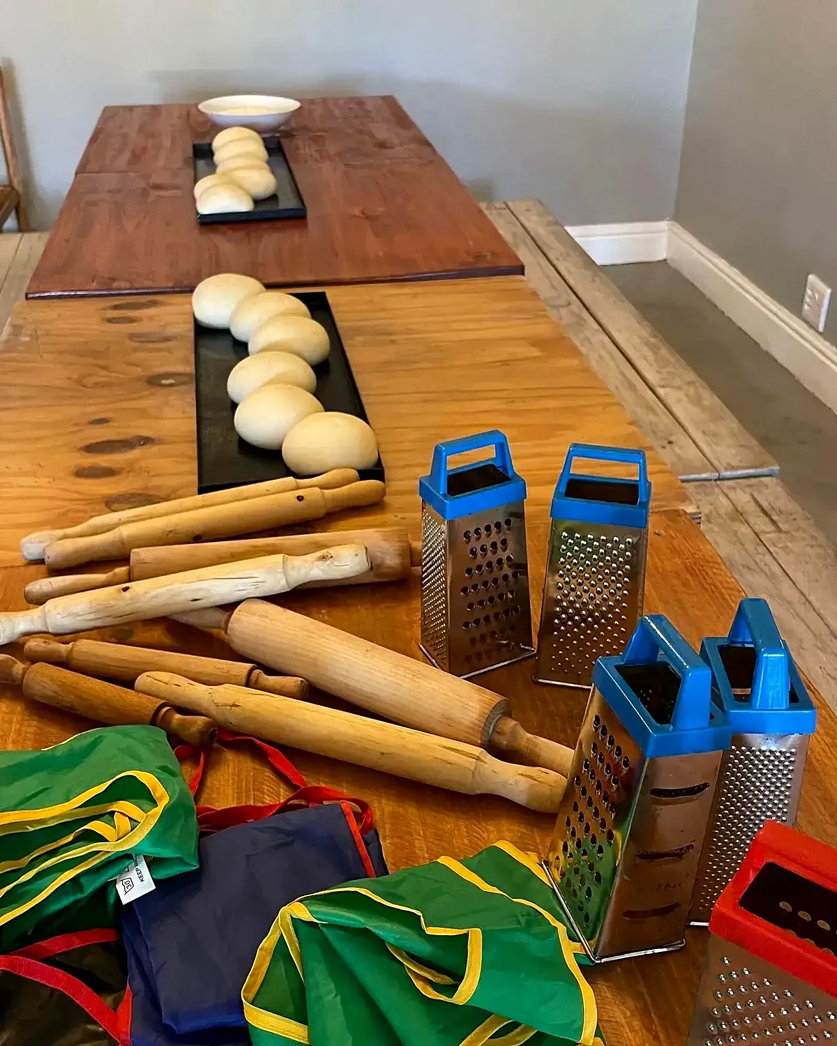 The pizza party table at Dario's, set with dough balls, rolling pins, graters and aprons
